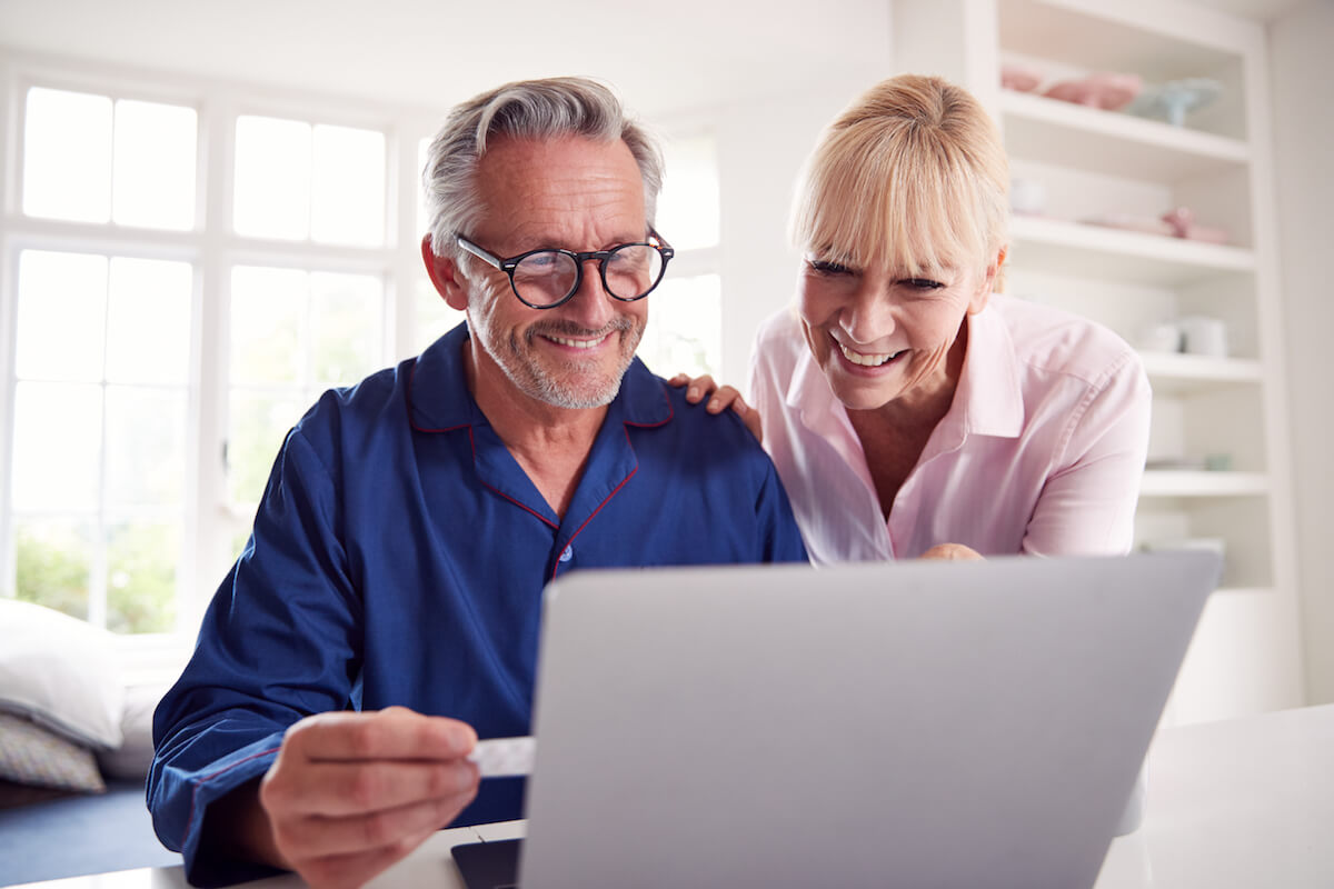 Mature Couple At Home Looking Up Information Online Using Laptop